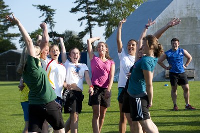 Feiern Junge Menschen freuen sich zusammen beim Sport draußen auf der Wiese